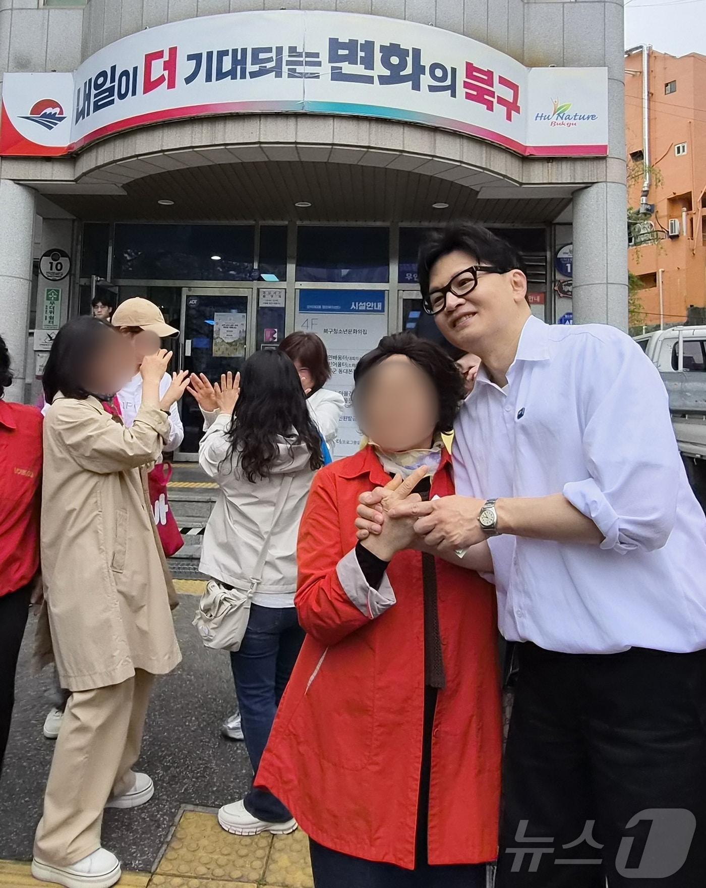 본문 이미지 - 한동훈 전 국민의힘 대표가 14일 부산 북구 만덕2동행정복지센터에서 전입신고를 한 뒤 주민들과 기념사진을 찍고 있다.2026.4.14 ⓒ 뉴스1 임순택 기자