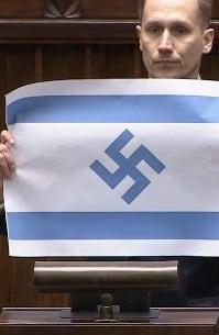 본문 이미지 - 폴란드 극우 민족주의 야당인 '콘페더라치아'(Konfederacja) 소속 콘라드 베르코비츠 의원이 폴란드 의회에서 나치 독일 문양이 그려진 이스라엘 국기를 들고 있다. (사진=베르코비츠 유튜브 갈무리)