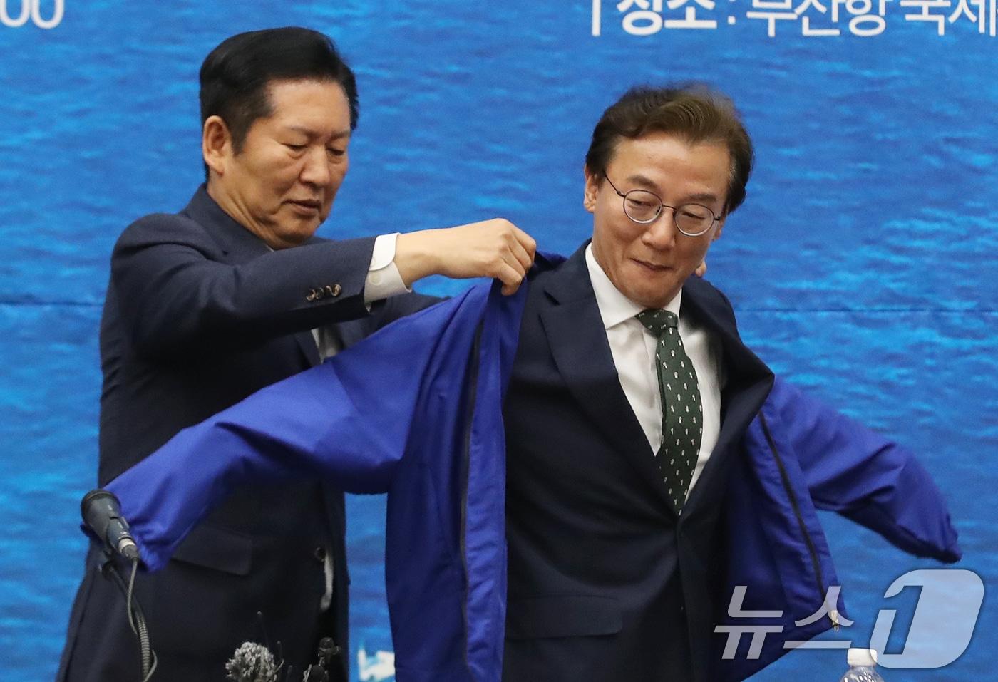 본문 이미지 - 정청래 더불어민주당 대표가 15일 부산 동구 부산항국제전시컨벤션센터에서 열린 부산 현장 최고위원회의에서 전재수 부산시장 후보에게 당 점퍼를 입혀주고 있다. 2026.4.15 ⓒ 뉴스1 윤일지 기자