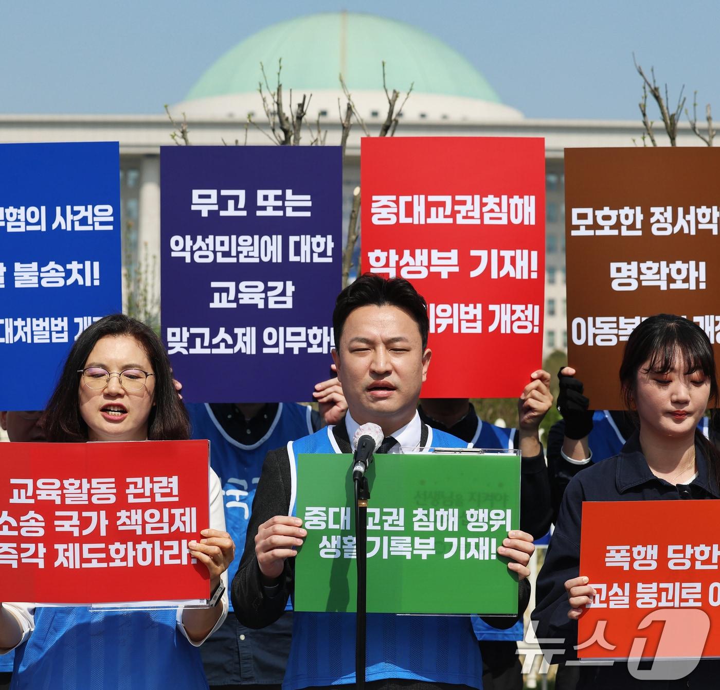 본문 이미지 - 한국교원단체총연합회 회원들이 15일 오전 서울 여의도 국회 앞에서 열린 '충남 교사 피습사건 대책 등 교권보호 제도 개선 촉구' 긴급 기자회견에서 구호를 외치고 있다. 참가자들은 이 자리에서 최근 충남 계룡 고교에서 발생한 제자의 교사 흉기 피습 사건을 교권 붕괴를 넘어선 교권 상실의 상징으로 규정하고, 정부의 실효성 있는 대책과 교권 보호 방안 마련을 촉구했다. 2026.4.15 ⓒ 뉴스1 오대일 기자