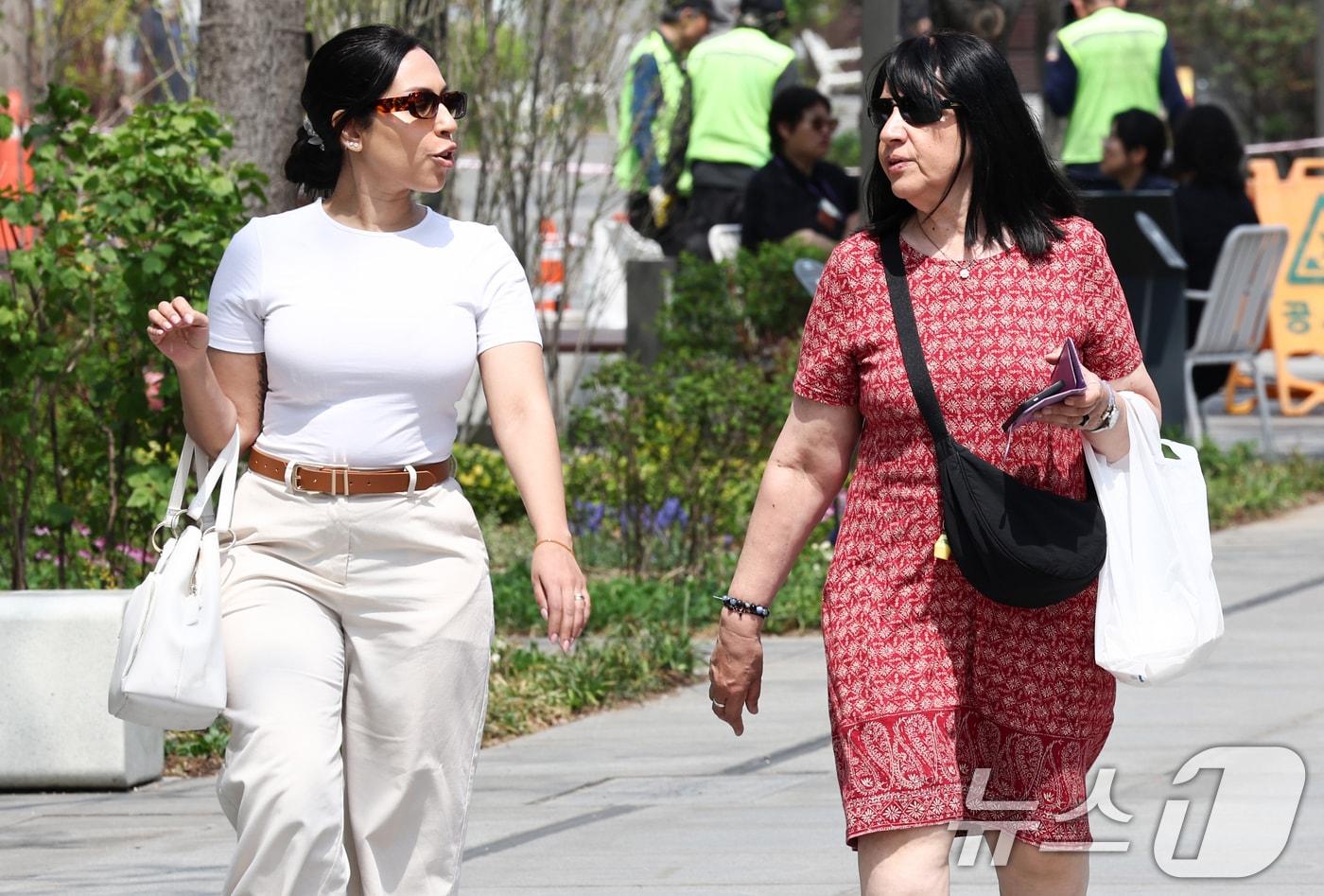 본문 이미지 - 서울 낮 최고 기온이 26도까지 오르는 등 초여름 날씨가 이어지는 15일 서울 종로구 광화문광장에서 외국인 관광객이 발걸음을 옮기고 있다. 2026.4.15 ⓒ 뉴스1 최지환 기자