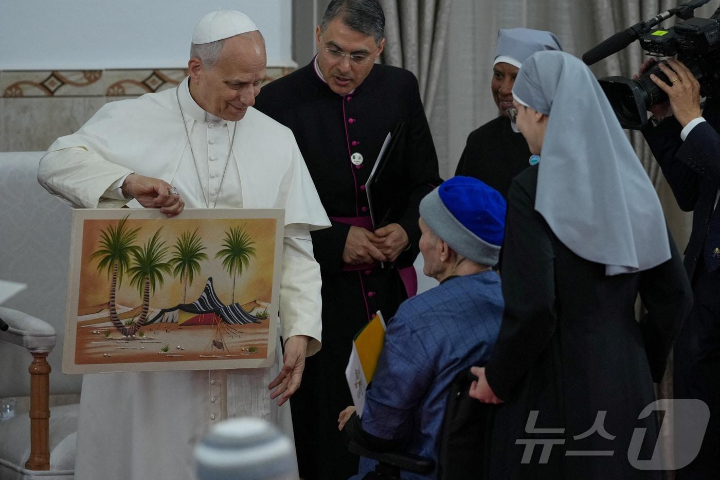 본문 이미지 - 14일(현지시간) 알제리 안나바에 위치한 '가난한 이들의 작은 자매회' 요양원을 찾은 레오 14세 교황이 선물을 받고 있다. 2026.04.14. ⓒ 로이터=뉴스1
