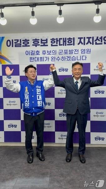 본문 이미지 - 제9회 전국동시지방선거 더불어민주당 경기 군포시장 후보 경선에서 탈락한 이길호 전 군포시의회 의장(오른쪽)이 15일 한대희 예비후보 지지를 선언한 후 기념촬영을 하고 있다. 2026.4.15/뉴스1 