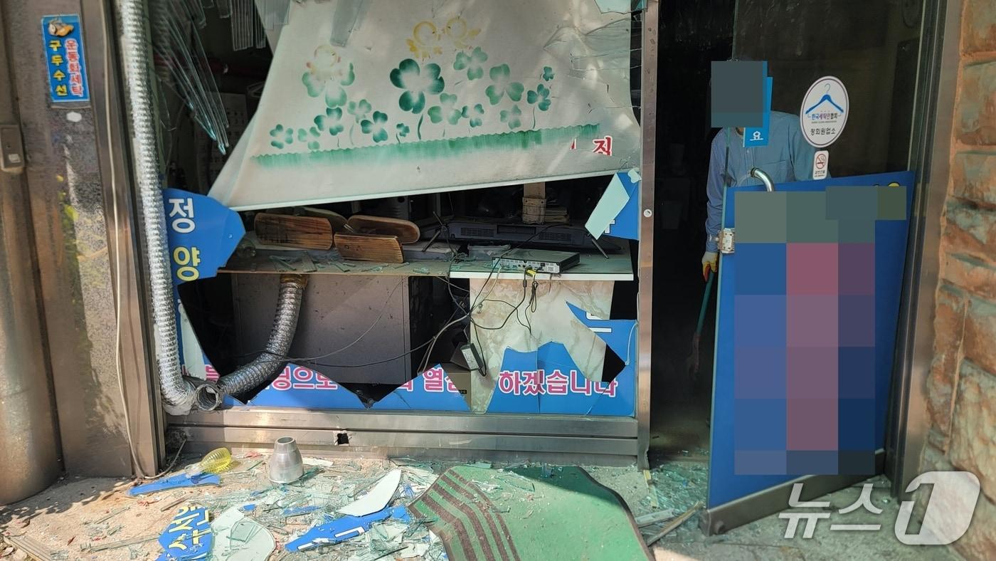 본문 이미지 - 자영업자가 깨진 유리를 정리하는 모습