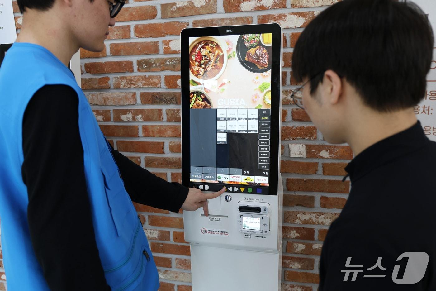 본문 이미지 - 단국대 장애학생 도우미가 배리어프리 키오스크에서 주문을 도와주고 있는 모습.(단국대 제공)