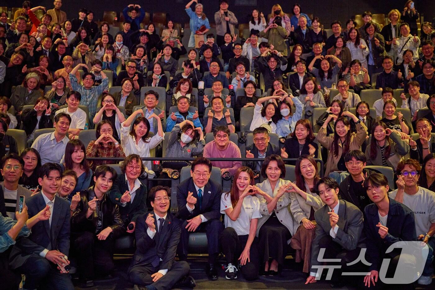 본문 이미지 - 이재명 대통령과 김혜경 여사가 15일 서울 용산구 CGV에서 영화 '내 이름은'을 관람한 뒤 정지영 감독 등 배우, 관객들과 기념촬영을 하고 있다. (청와대 제공. 재판매 및 DB 금지) 2026.4.15 ⓒ 뉴스1 허경 기자