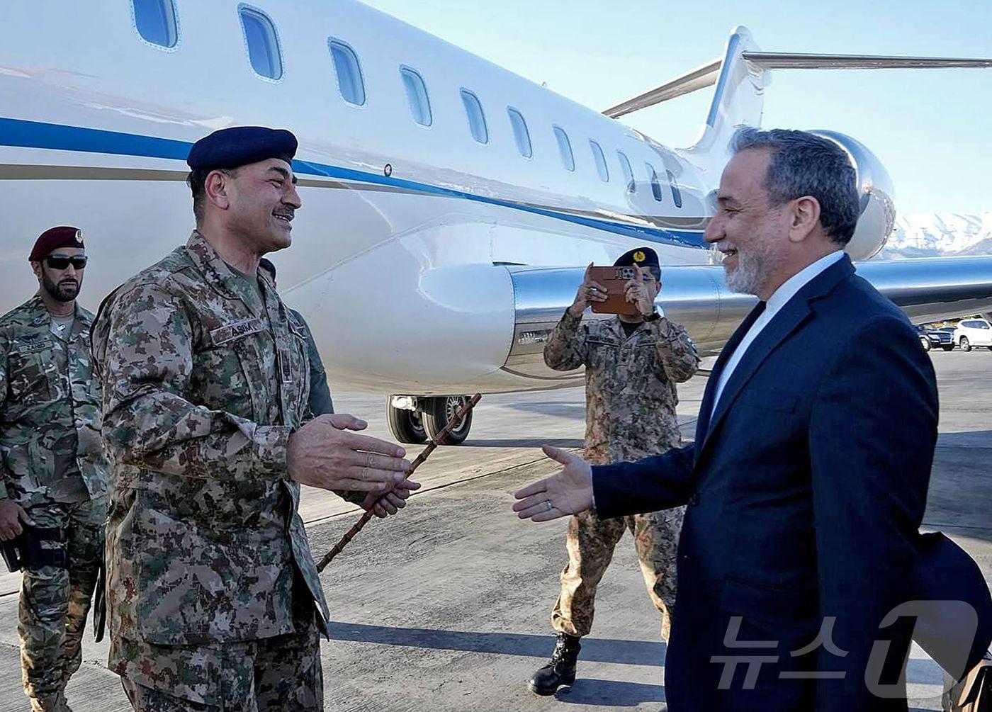 본문 이미지 - 15일(현지시간) 이란 외무장관 아바스 아라그치(오른쪽)가 테헤란 공항에 도착한 파키스탄 육군참모총장 아심 무니르를 환영하고 있다. 이란 외무부가 제공한 사진. ⓒ AFP=뉴스1