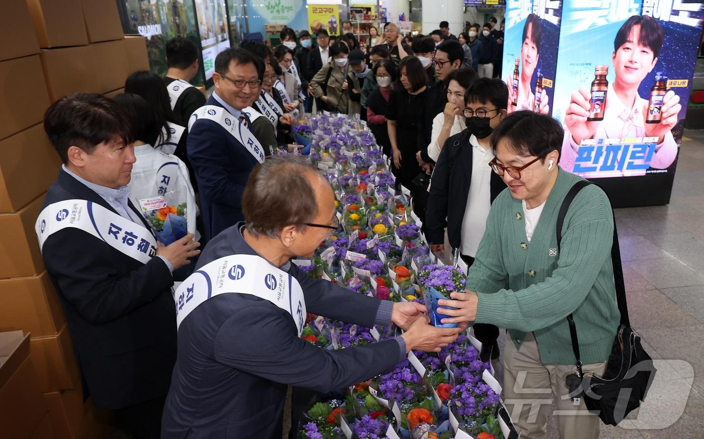 본문 이미지 - 16일 오전 서울 종로구 광화문역 대합실에서 서울교통공사 관계자들이 시민들에게 꽃 화분 무료 나눔 행사를 하고 있다. 2026.4.16 ⓒ 뉴스1 김성진 기자