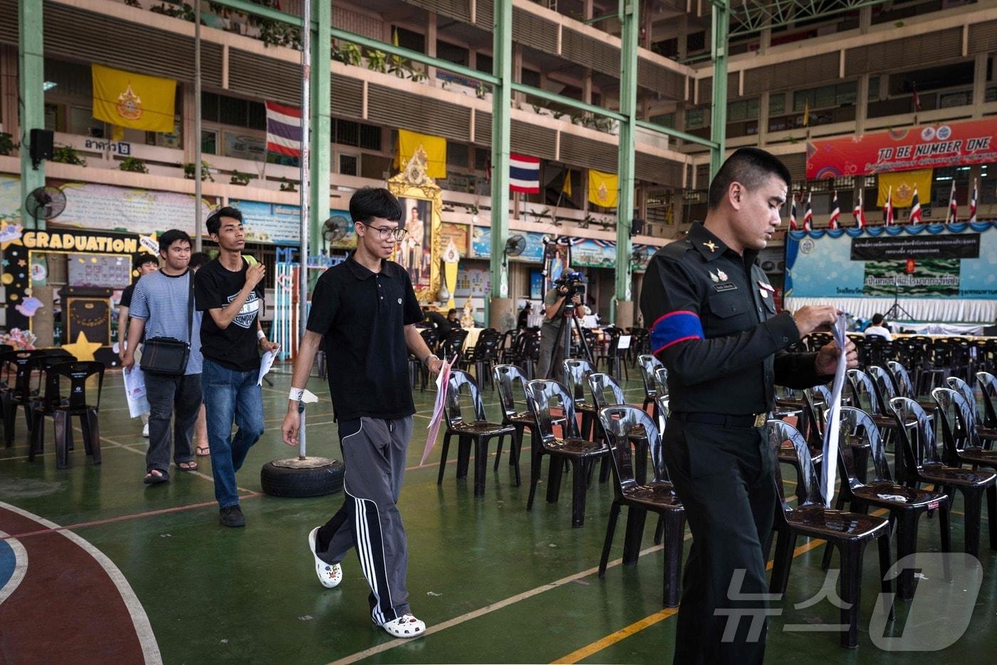 본문 이미지 - 7일(현지시간) 태국 방콕 왓맛찬티카람 학교에서 징집 대상자들이 징병 추첨에 앞서 신체검사를 받으러 이동하고 있다. 2026.04.07. ⓒ AFP=뉴스1
