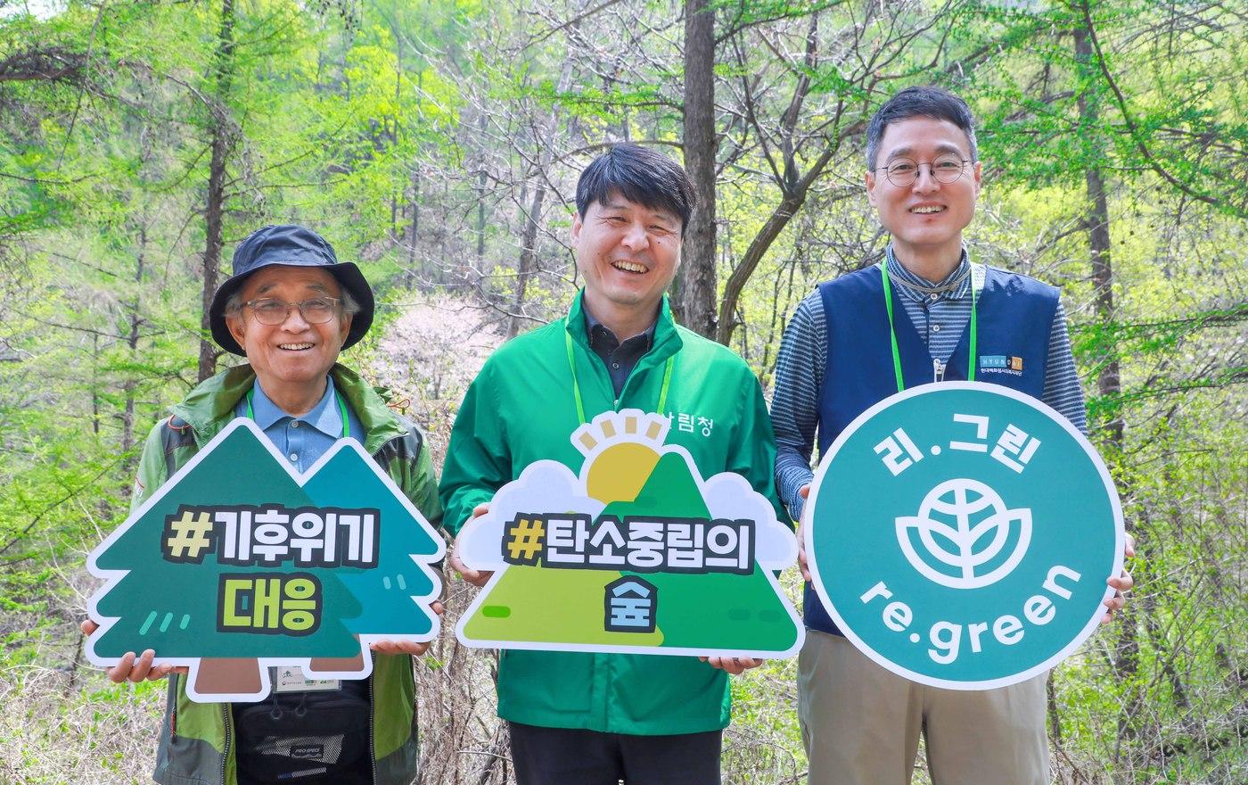 본문 이미지 - 16일 경기도 용인시 처인구 이동읍 묵리 '제2호 현대백화점그룹 탄소중립의 숲'에서 윤영식 현대지에프홀딩스 부사장(사진 오른쪽)과 송준호 북부지방산림청장(사진 가운데), 김석권 생명의숲 대표(사진 왼쪽)이 기념 사진을 촬영하고 있다.(현대백화점그룹 제공)
