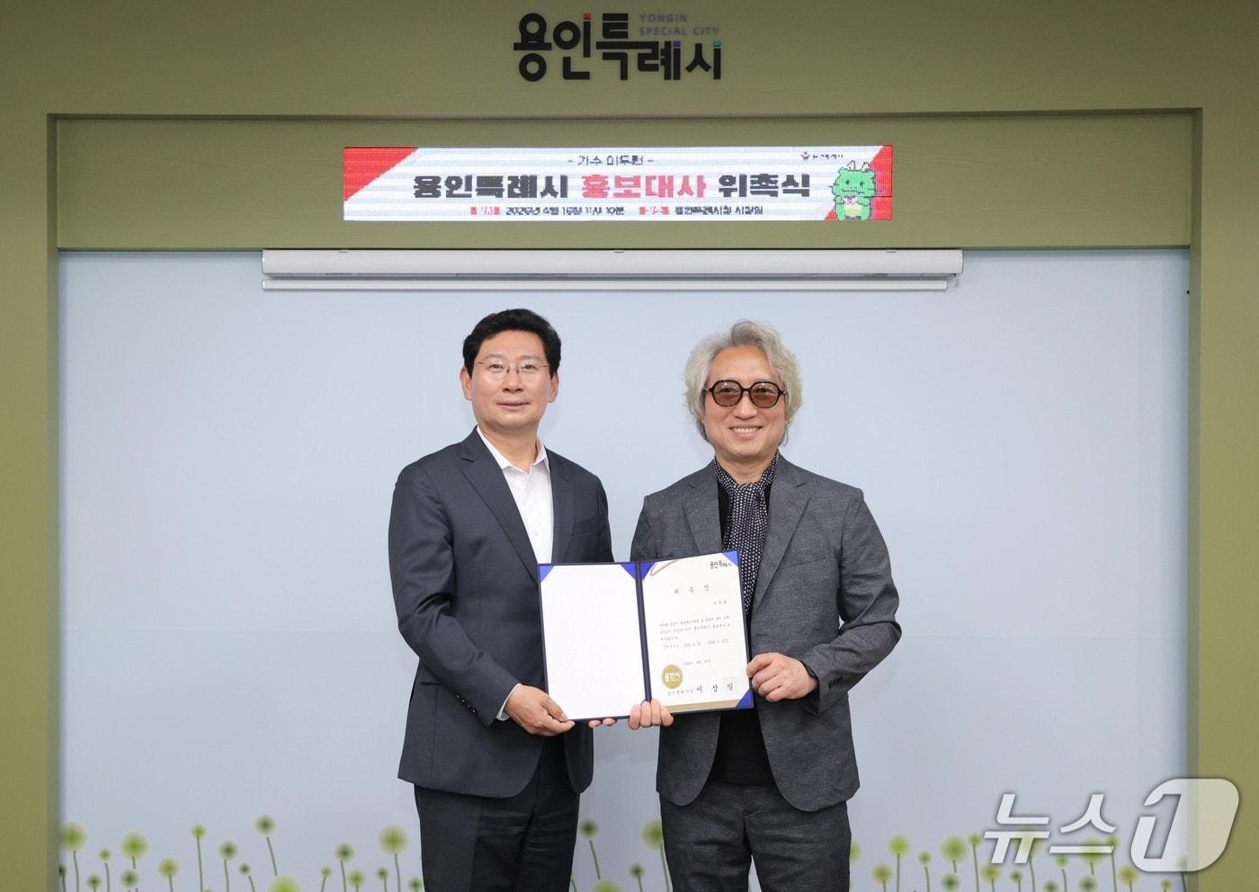 본문 이미지 - 이상일 시장(왼쪽)이 16일 시청 시장실에서 가수 이두헌 씨에게 홍보대사 위촉장을 전달하고 기념촬영을 하고 있다.(용인시 제공)