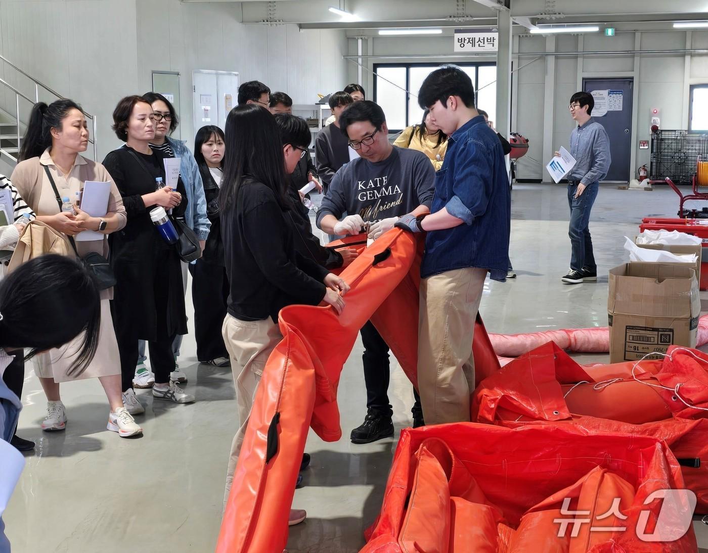 본문 이미지 - 16일 원주시 남한강 방제비축센터에서 진행된 '수질오염사고 대비 방제교육'에서 참석자들이 오일펜스 운용 방법에 대한 교육을 받고 있다.(한강청 제공)