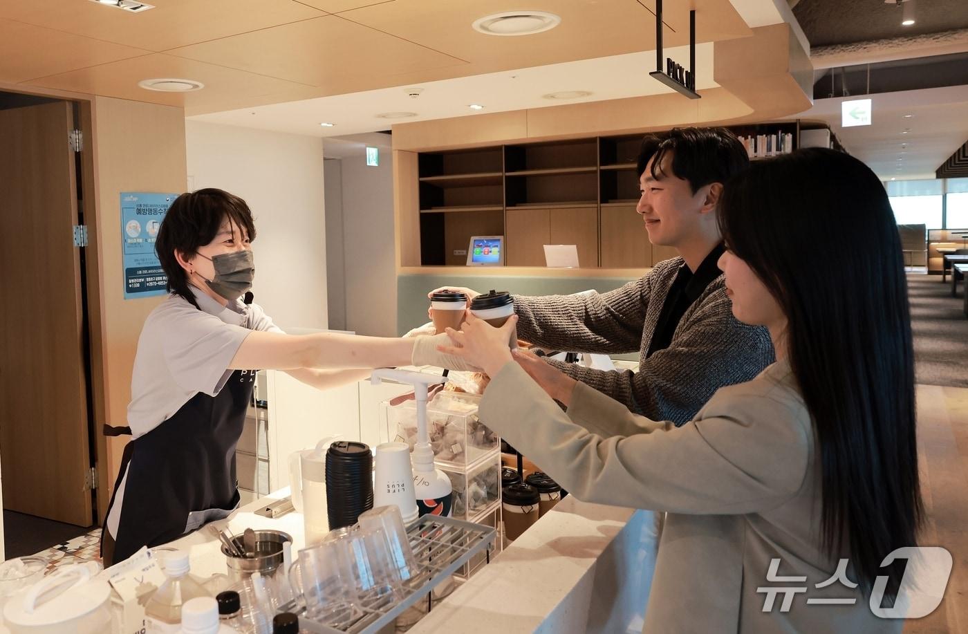 본문 이미지 - 한화생명 본사 63빌딩 사내 카페에서 바리스타 직원이 임직원에게 음료를 전달하고 있는 모습/사진제공=한화생명