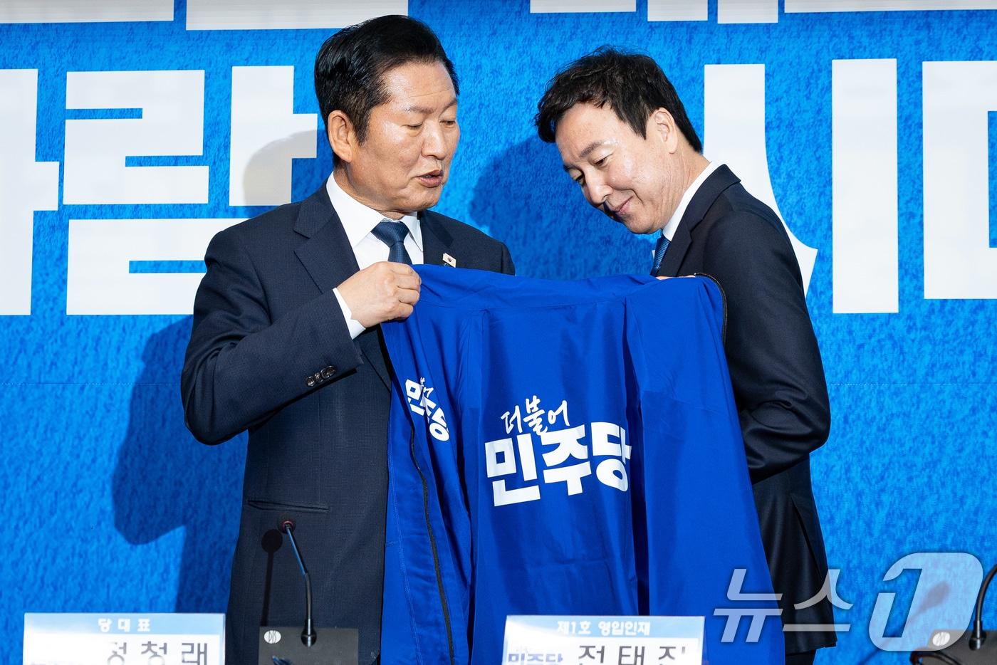 본문 이미지 - 정청래 더불어민주당 대표가 17일 서울 여의도 국회에서 열린 제1차 인재영입식에서 전태진 변호사에게 당 점퍼를 입혀주고 있다. 2026.4.17 ⓒ 뉴스1 유승관 기자