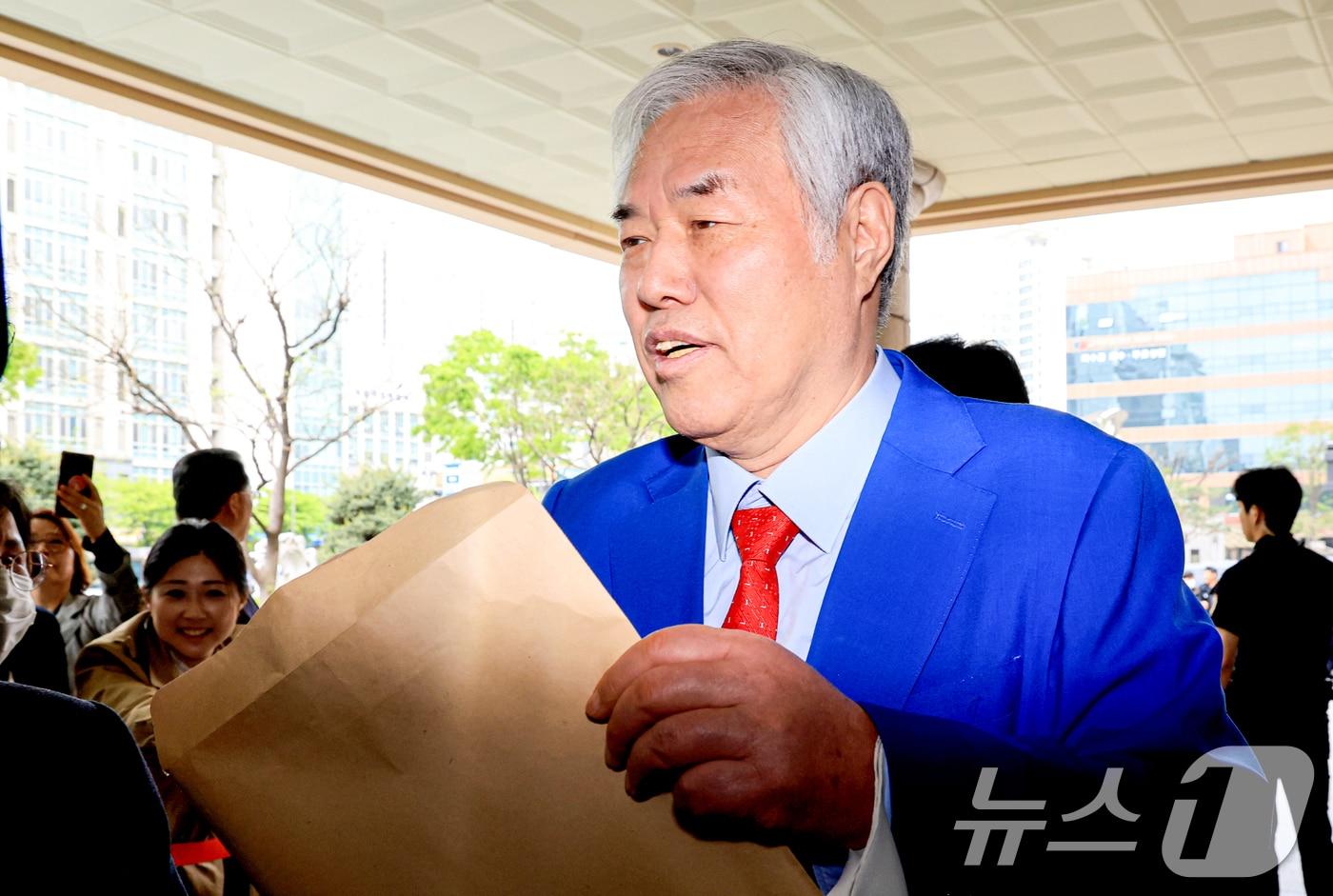 본문 이미지 - 서울서부지법 난동 사태 배후로 지목돼 수건조물침입교사 혐의 등으로 기소된 전광훈 사랑제일교회 목사가 17일 서울 마포구 서울서부지법에서 열린 재판을 마치고 입장문을 취재진에게 건네고 있다. 2026.4.17 ⓒ 뉴스1 이호윤 기자