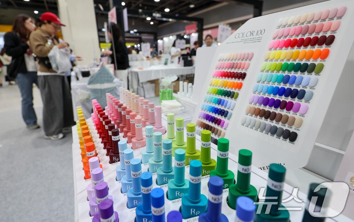 본문 이미지 - 17일 서울 서초구 aT센터에서 열린 네일콘 & 뷰티콘 코리아(KONAIL EXPO)을 찾은 관람객들이 다양한 색상의 네일팁을 보며 제품을 고르고 있다. 네일, 화장품, 반영구 화장, 두피문신, 속눈썹 연장 및 펌, 왁싱, 미용 의료 관련 기기 등 최신 트렌드와 비지니스 기회를 제공하는 B2B·B2C 전시회인 이번 행사는 오는 19일까지 열린다. 2026.4.17 ⓒ 뉴스1 안은나 기자