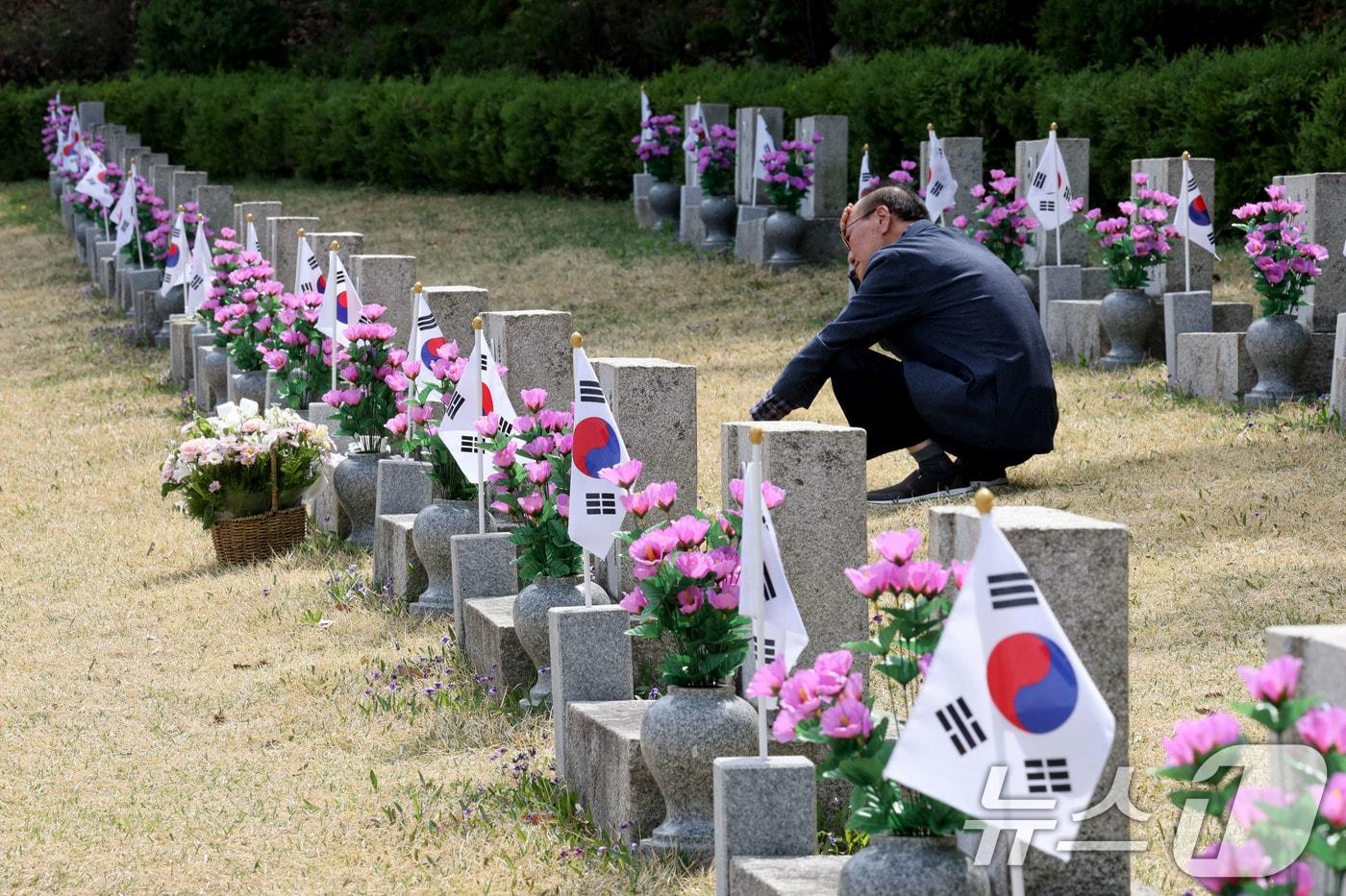 본문 이미지 - 4.19혁명 기념일을 앞둔 17일 오후 서울 강북국 국립4.19 민주묘지를 찾은 유족이 참배 후 묘비를 바라보고 있다.  ⓒ 뉴스1 이광호 기자