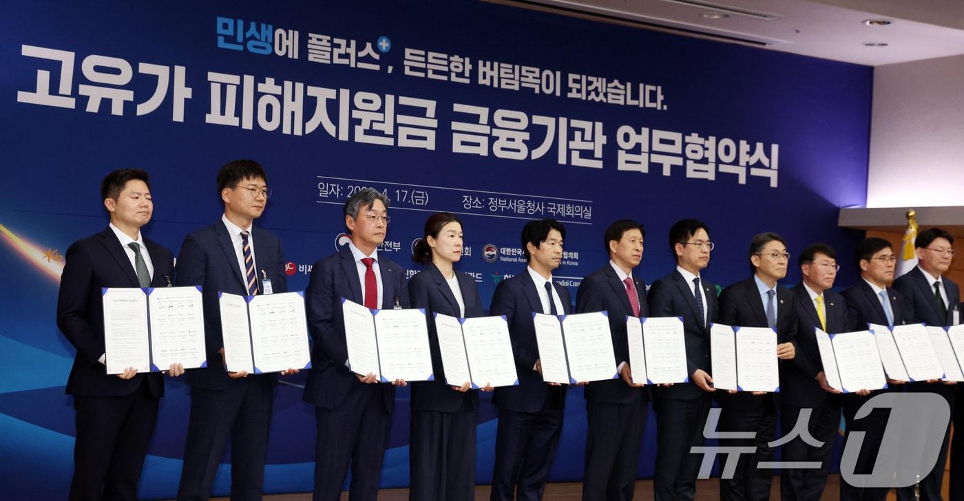 본문 이미지 - 17일 오후 서울 종로구 정부서울청사 별관에서 열린 고유가 피해지원금 금융기관 업무협약식에서 김민재 행정안전부 차관, 권대영 금융위원회 부위원장 및 금융기관 대표자들이 협약서를 들고 기념촬영을 하고 있다. 2026.4.17 ⓒ 뉴스1 김명섭 기자