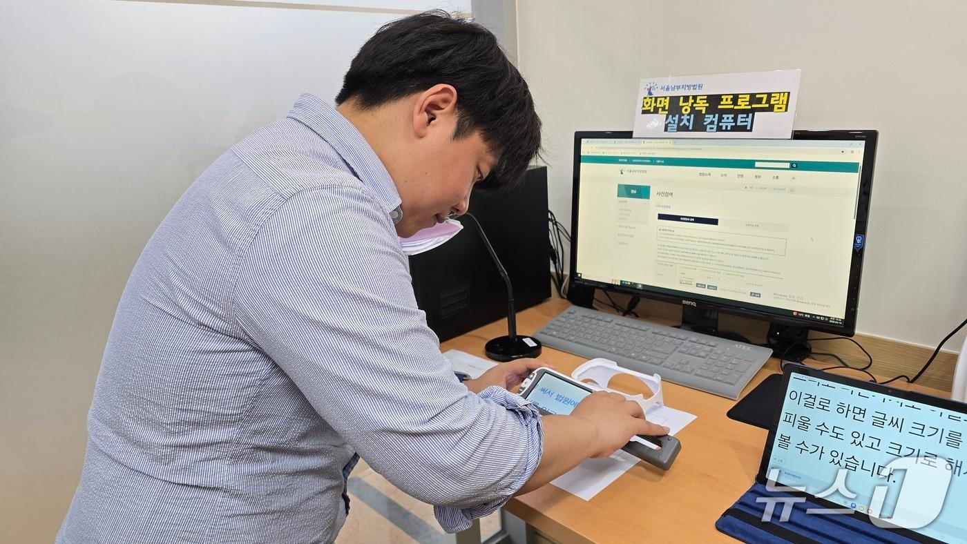본문 이미지 - 서울남부지방법원 사법접근센터에 설치된 저시력자 지원 글자 확대기기를 기자가 체험하는 모습./뉴스1 ⓒNews1 윤주영 기자