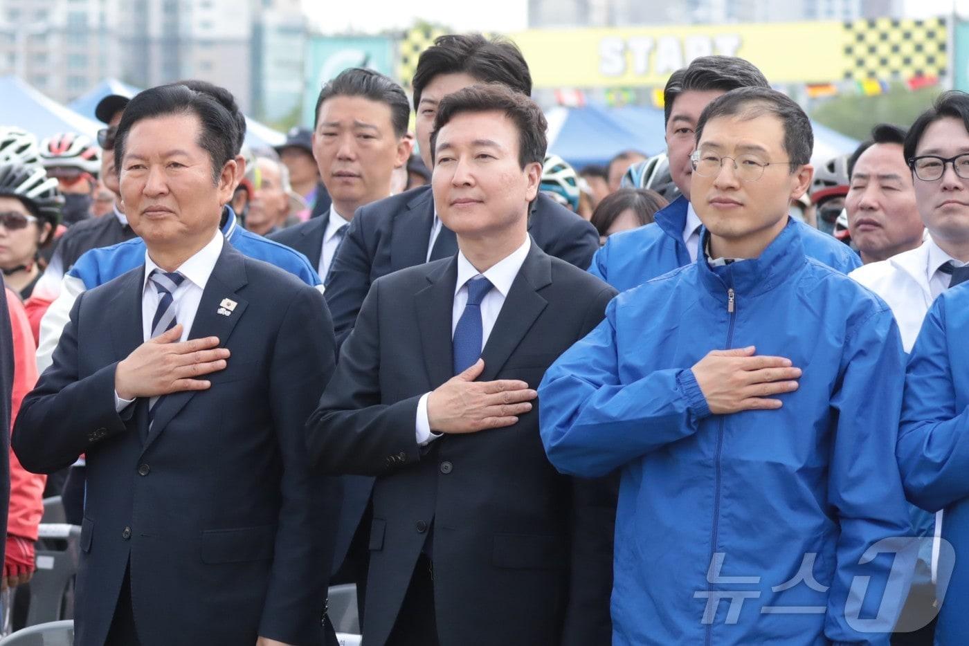 본문 이미지 - 정청래 더불어민주당 대표(왼쪽)와 전태진 변호사(가운데), 김상욱 의원(오른쪽)이 18일 울산 태화강변 남구 둔치에서 열린 '울산 자전거 대축전'에 참석해 국민의례를 하고 있다. 2026.4.18 ⓒ 뉴스1 박정현 기자