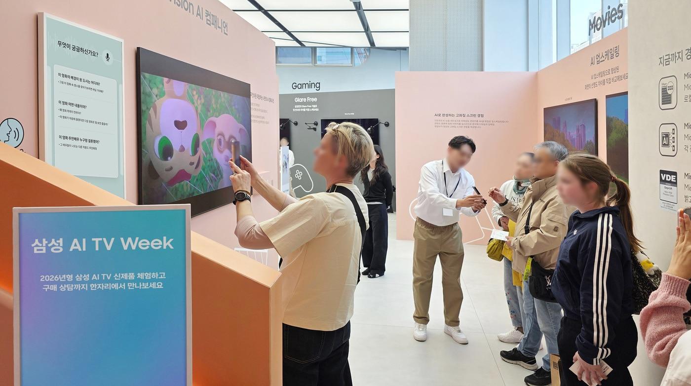 본문 이미지 - '삼성 AI TV 위크' 방문객들이 영화를 시청하며 삼성 TV만의 통합 AI 플랫폼 '비전 AI 컴패니언'에 궁금한 내용을 질문하고 있다.
