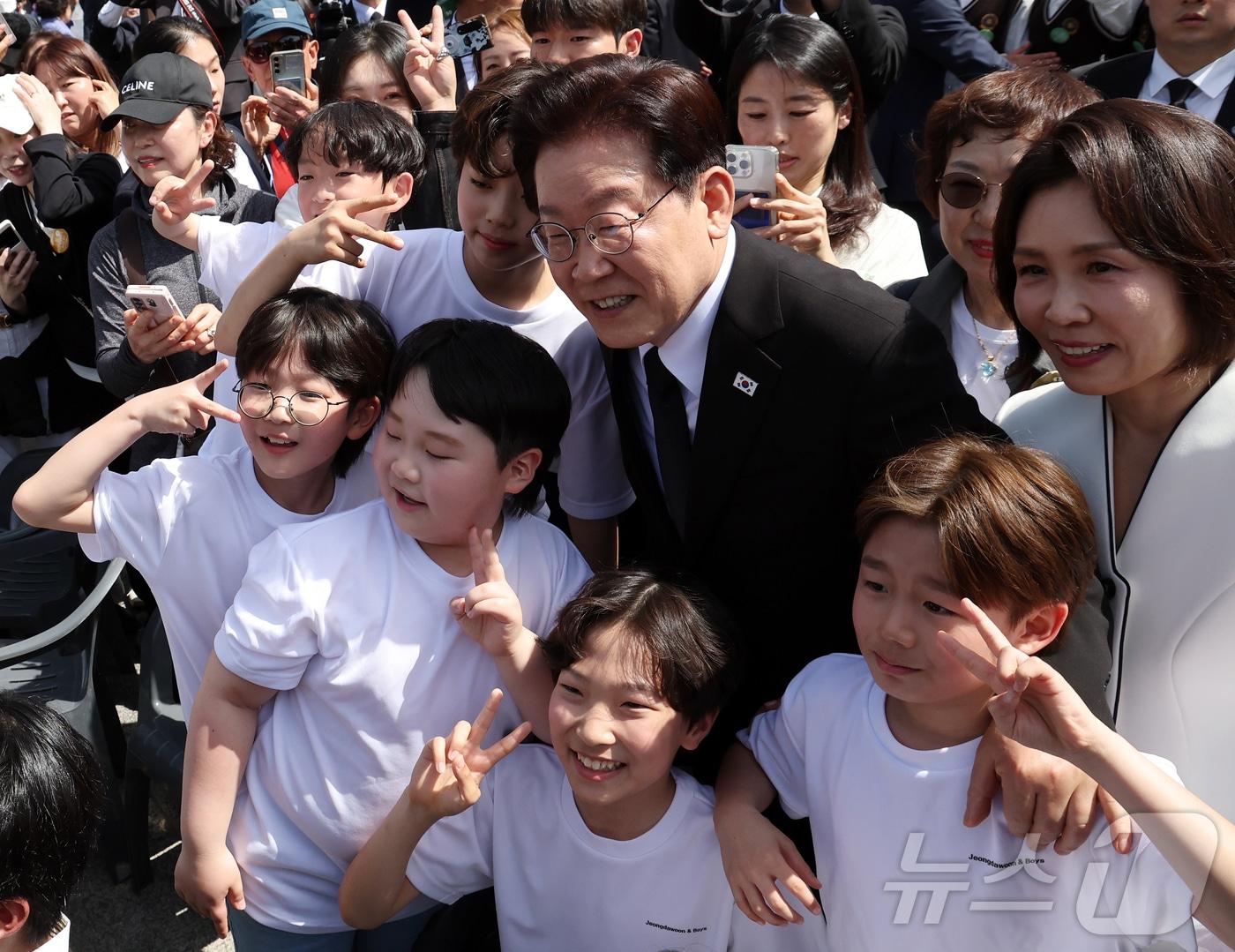 본문 이미지 - 이재명 대통령과 김혜경 여사가 19일 서울 강북구 수유동 국립4·19민주묘지에서 열린 제66주년 4·19혁명 기념식을 마친 뒤 참가 학생들과 기념 촬영을 하고 있다. 2026.4.19 ⓒ 뉴스1 허경 기자