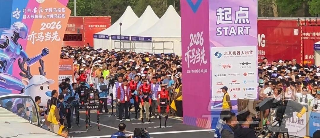 본문 이미지 - 19일 오전 7시 30분 개최된 '제2회 베이징 이좡 휴머노이드 로봇 하프마라톤' 출발선에 휴머노이드로봇과 사람들이 함께 서있다. ⓒ 뉴스1 정은지 특파원