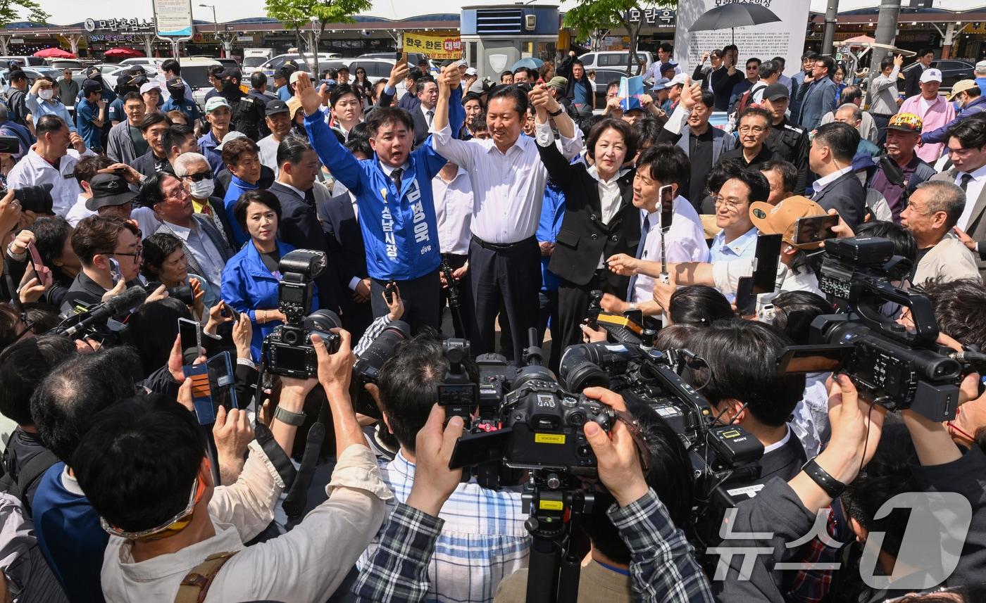 본문 이미지 - 정청래 더불어민주당 대표가 추미애 경기도지사 후보, 김병욱 성남시장 후보 등과 19일 경기도 성남시 모란민속5일장을 방문해 두 팔을 들어보이고 있다. (공동취재) 2026.4.19 ⓒ 뉴스1 이승배 기자