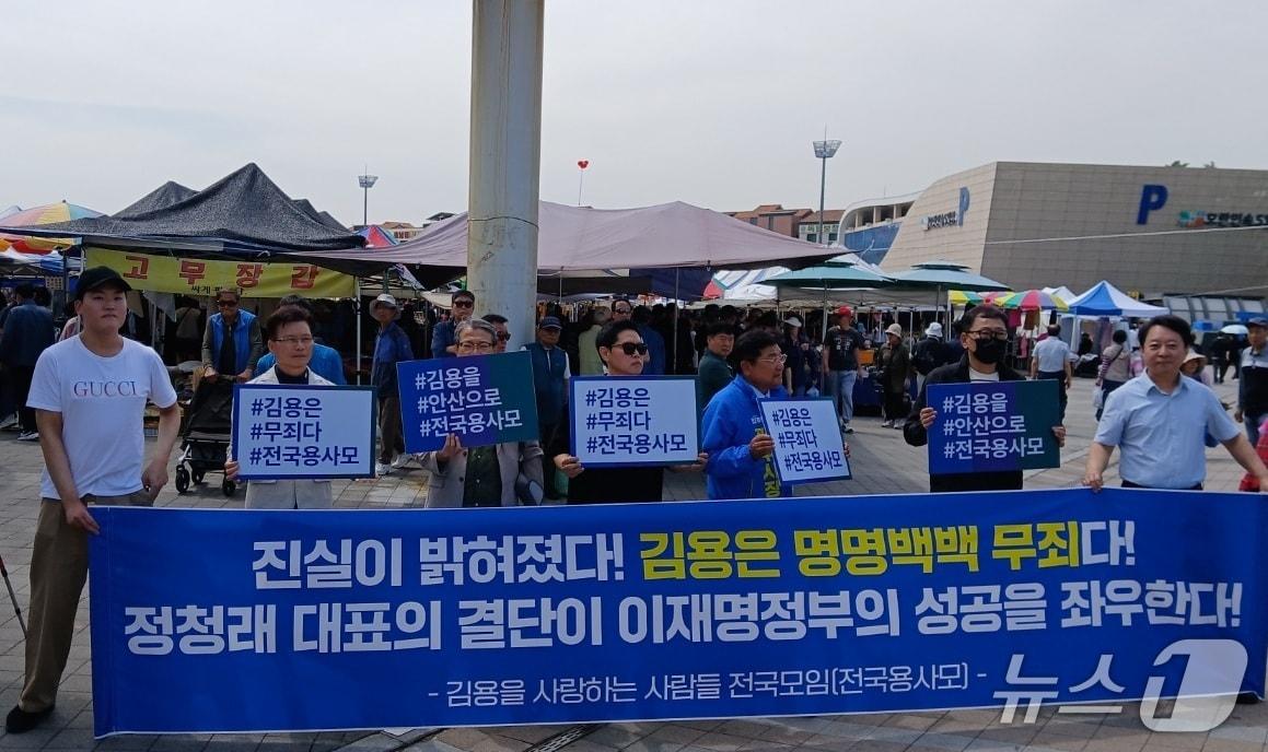 본문 이미지 - 19일 오후 경기 성남시 모란민속 5일장에서 김용 전 민주연구원 부원장 지지자들이 '안산갑 공천'을 촉구하는 대형 현수막을 펼쳐 보이고 있다.2026.04.19/뉴스1 ⓒ News1 송용환 기자