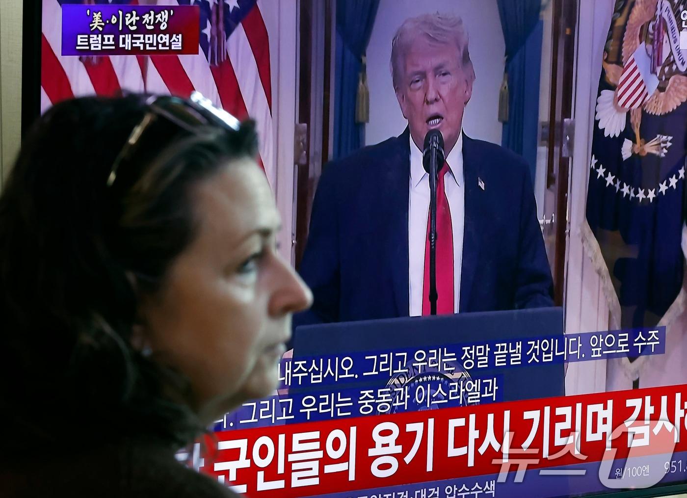 본문 이미지 - 2일 오전 서울시 용산구 서울역 대합실에서 한 외국인 관광객이 도널드 트럼프 미국 대통령의 이란 전쟁 상황 관련 대국민 연설 TV 생중계를 지켜보고 있다. ⓒ 뉴스1 박정호 기자