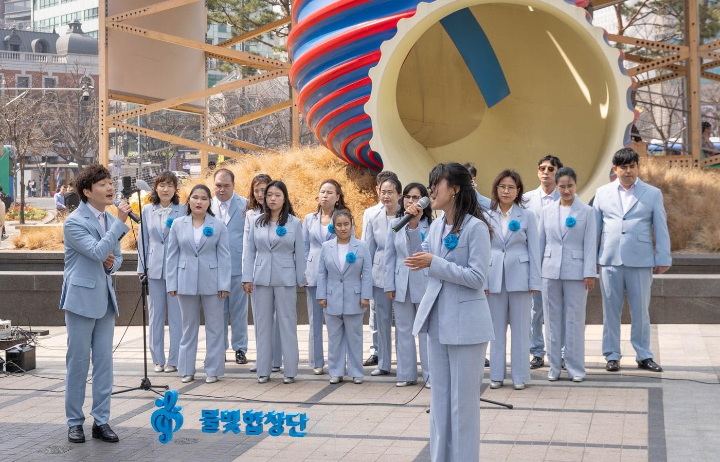 본문 이미지 - 코웨이 물빛합창단이 청계광장에서 봄맞이 버스킹 공연을 진행하고 있다.(코웨이 제공)