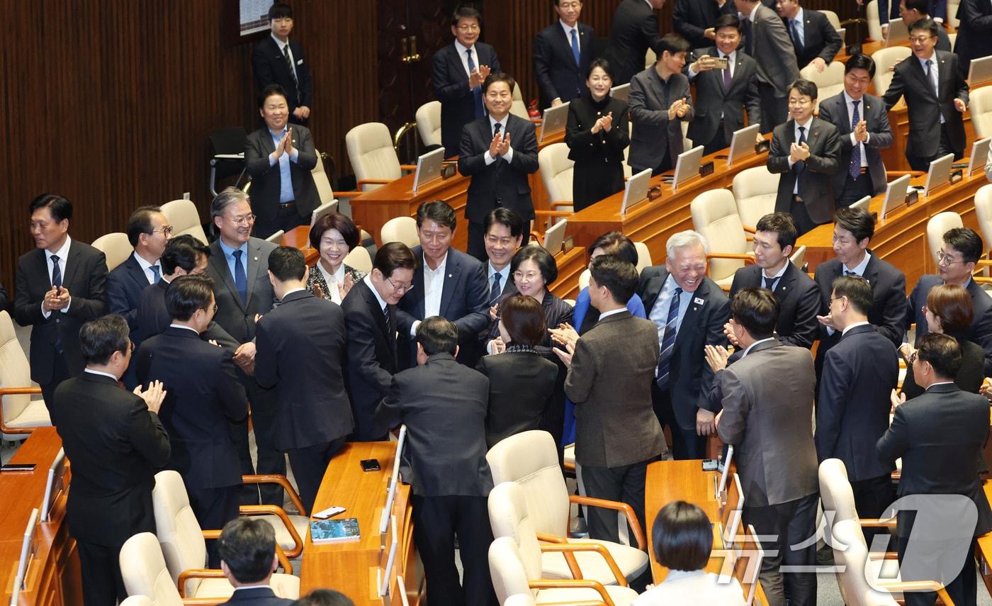 본문 이미지 - 이재명 대통령이 지난 4월 서울 여의도 국회 본회의장에서 중동 사태 대응 등을 위한 추가경정예산안에 대한 시정연설에 앞서 더불어민주당 의원들과 악수를 하고 있다. 2026.4.2 ⓒ 뉴스1 국회사진기자단
