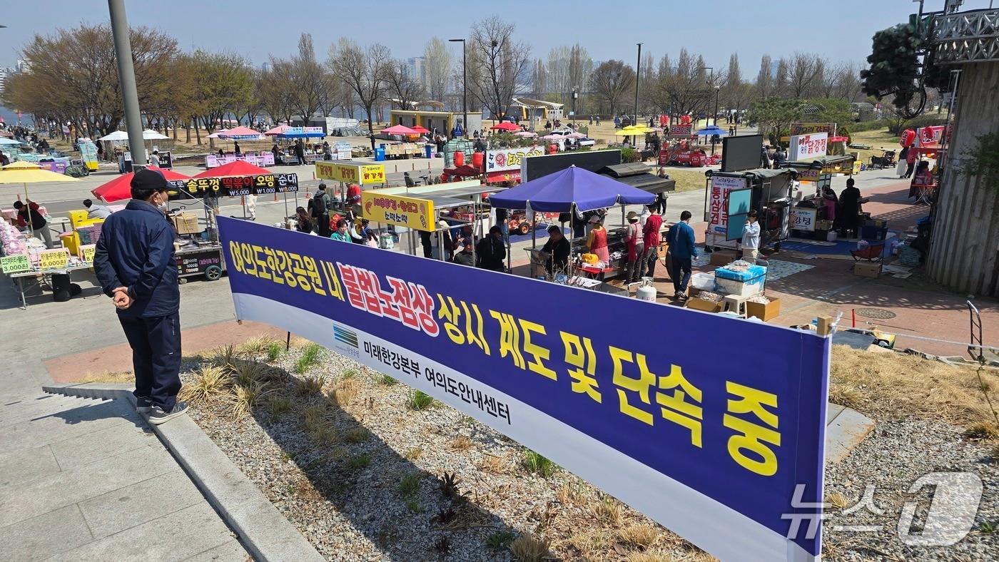 본문 이미지 - 2일 서울 영등포구 여의도 한강공원에 불법 노점상을 단속한다는 내용의 서울시 현수막이 걸렸다./뉴스1 ⓒNews1 윤주영 기자