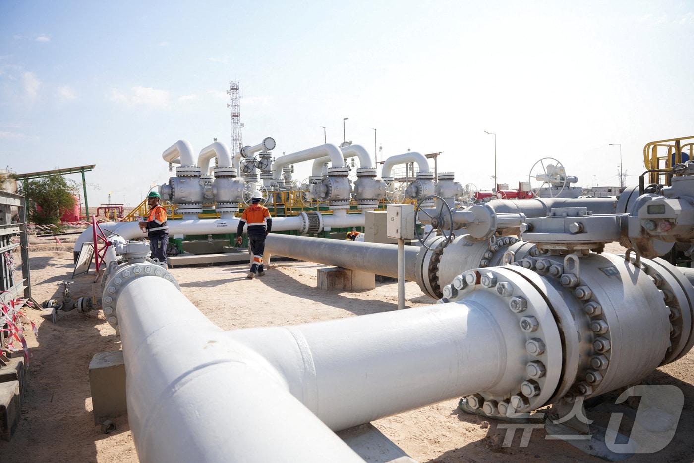 본문 이미지 - 2026년 3월 4일 이라크 바스라의 루마일라 유전에서 노동자들이 파이프라인 위를 걷고 있다. 2026.3.11. ⓒ 뉴스1 ⓒ 로이터=뉴스1