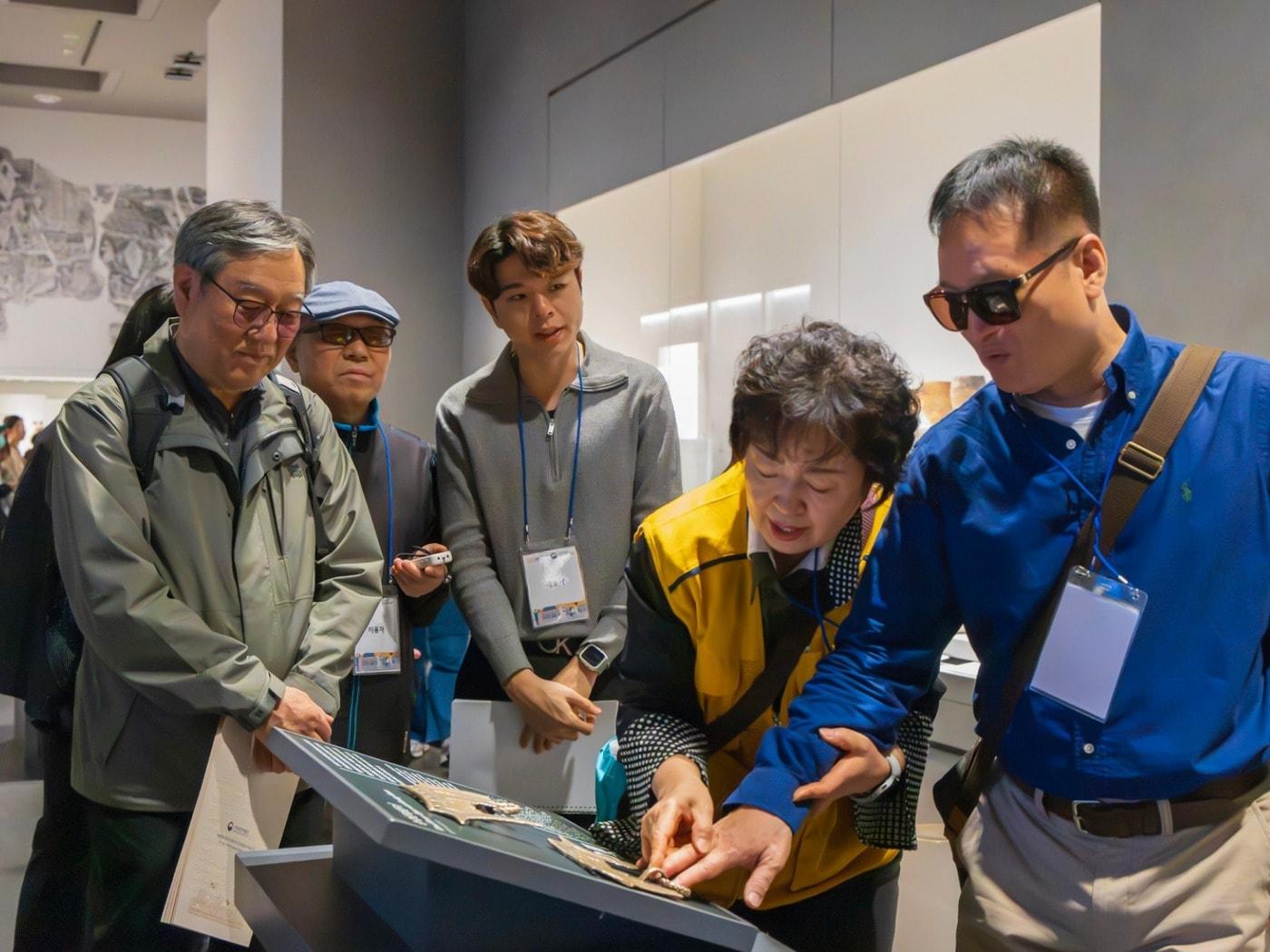 본문 이미지 - 현장영상해설 투어 참가자들이 촉각교구 체험을 하고 있다.(서울관광재단 제공)