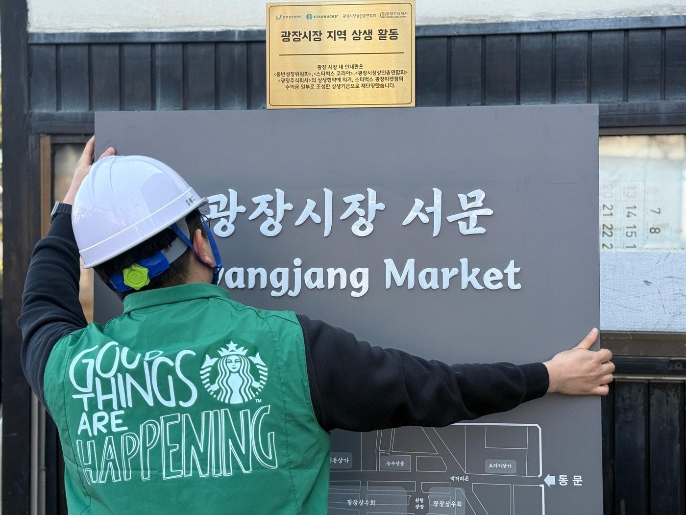 본문 이미지 - 스타벅스 임직원이 광장시장 이정표를 교체하는 모습.(스타벅스 코리아 제공)