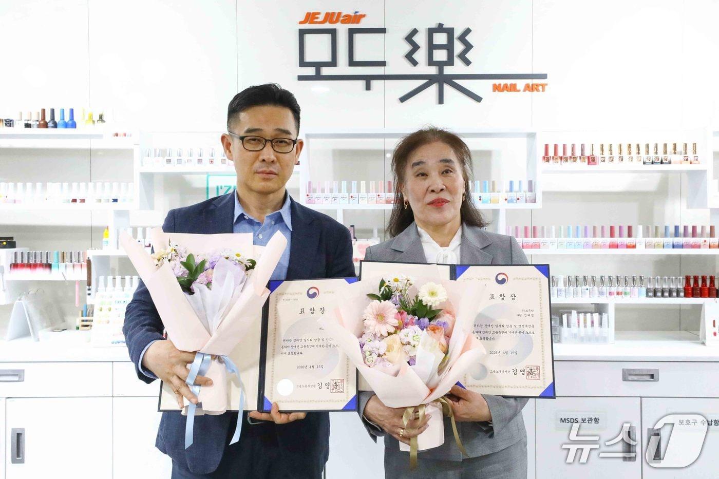 본문 이미지 - 15일 열린 '2026년 장애인 고용촉진유공자 정부포상'에서 고용노동부 장관상 사업주 부문과 근로자 부문을 각각 수상한 이정석 제주항공 모두락(樂) 대표이사(왼쪽)와 전혜림 모두락 헬스키퍼가 모두락 1호점에서 기념 사진을 촬영한 모습(제주항공 제공). 2026.4.15.