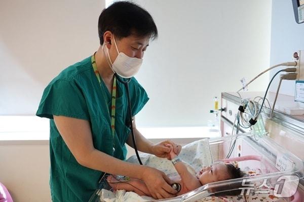 본문 이미지 - 지난 3월 이병섭 서울아산병원 신생아과 교수가 퇴원을 앞둔 한결이를 진료하는 모습. (병원 제공)