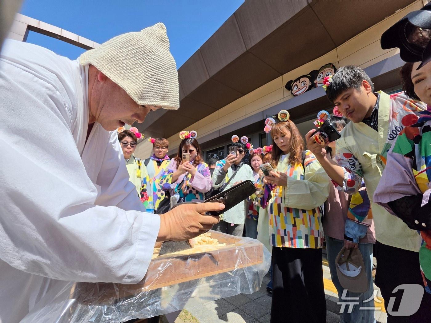 본문 이미지 - 음성품바축제 프로그램 '엿치기'에 관심을 보이고 있는 대만 여행업계 관계자들.(음성군 제공. 재판매 및 DB금지)