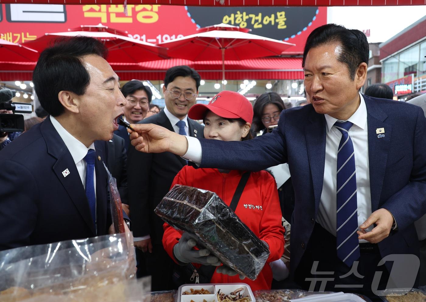 본문 이미지 - 정청래 더불어민주당 대표가 20일 충남 보령 대천항수산시장에서 박수현 충남도지사 후보에게 김을 먹여주고 있다. 2026.4.20 ⓒ 뉴스1 김기태 기자