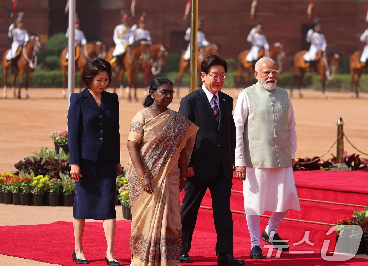 본문 이미지 - 이재명 대통령과 김혜경 여사가 20일 뉴델리 대통령궁 광장에서 열린 공식환영식에서 드라우파디 무르무 인도 대통령, 나렌드라 모디 인도 총리와 의장대를 사열한 뒤 이동하고 있다. 2026.4.20 ⓒ 뉴스1 이재명 기자