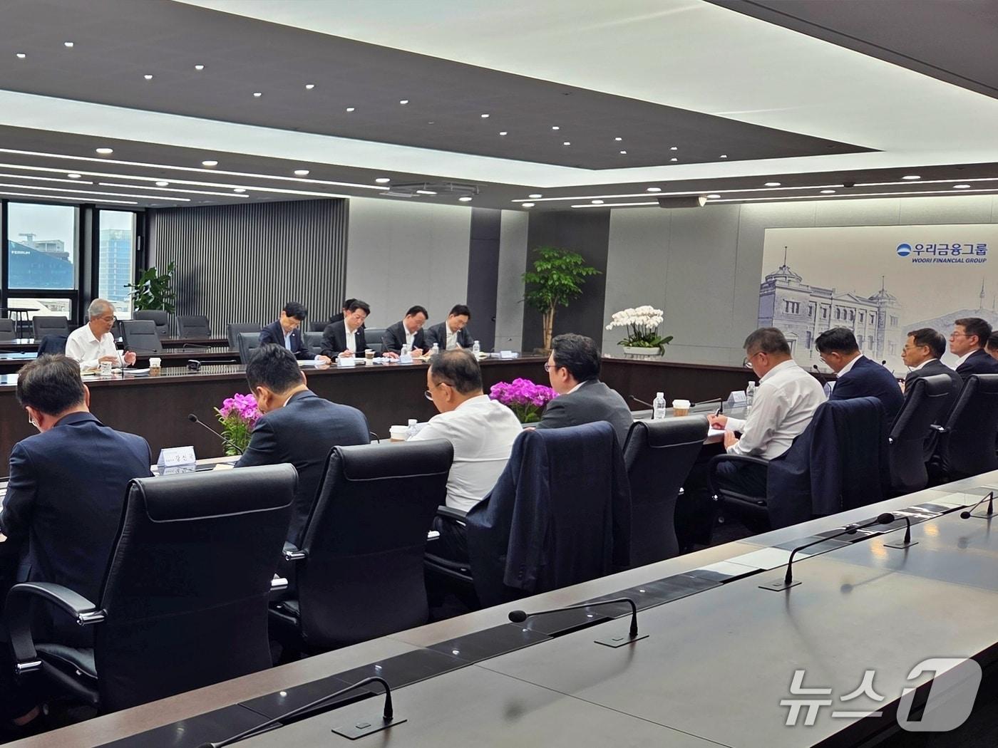본문 이미지 - 우리금융그룹은 지난 17일 임종룡 회장 주재로 '4월 첨단전략산업금융협의회'를 개최했다. 이날 임 회장(뒷줄 왼쪽 첫 번째)은 생산적·포용적 금융의 골든타임을 강조하며 지원 속도를 높일 것을 당부했다. 26.04.17 / 사진제공=우리금융
