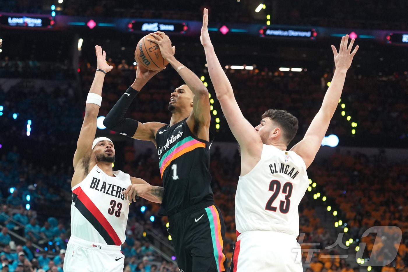 본문 이미지 - 샌안토니오 스퍼스의 빅토르 웸반야마(가운데)가 20일(한국시간) 열린 포틀랜드 트레일블레이저스와 2025-26 NBA 플레이오프 1라운드 1차전에서 35점을 넣어 팀 승리를 이끌었다. ⓒ 로이터=뉴스1