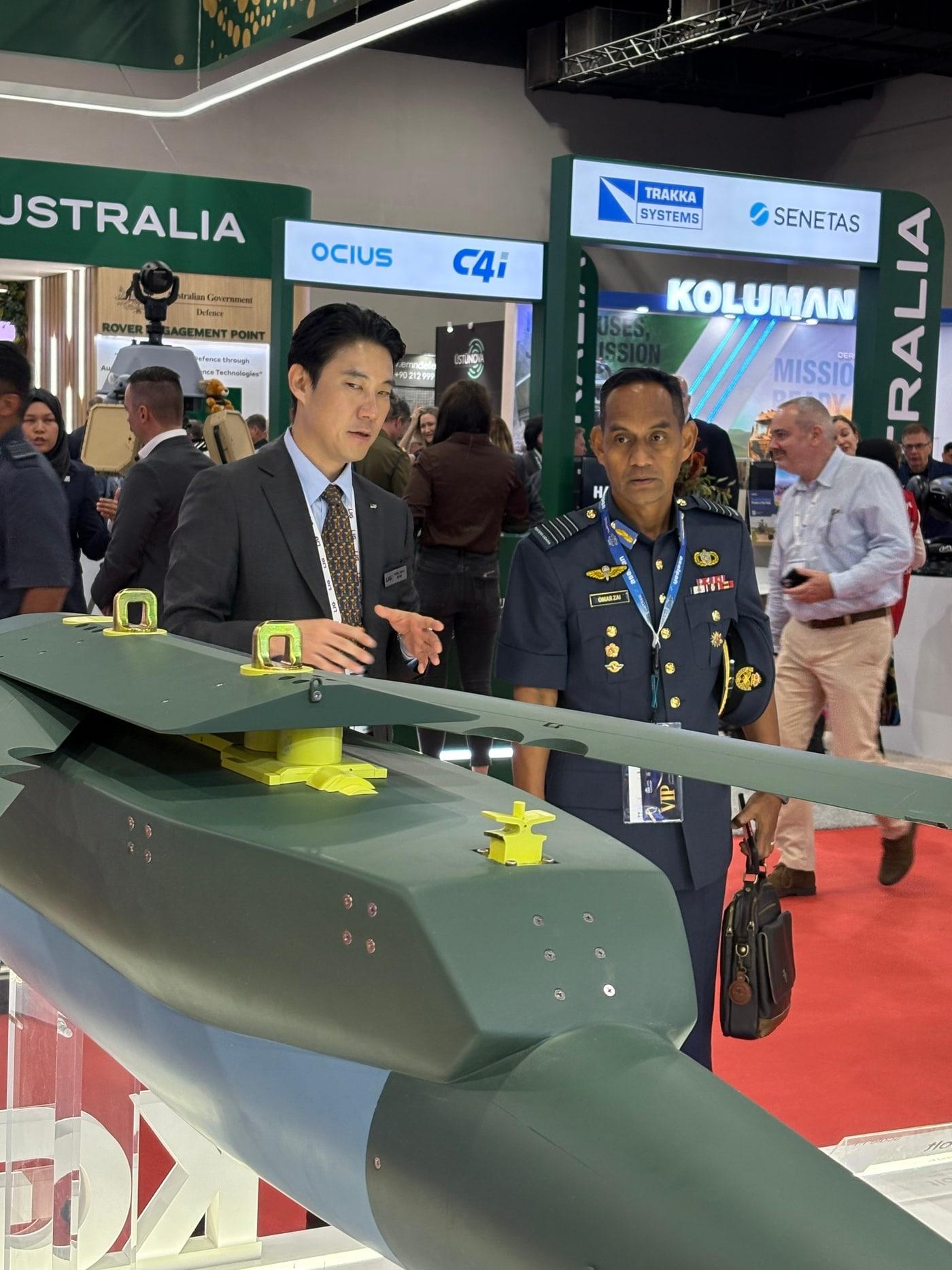 본문 이미지 - 'DSA 2026'에서 LIG Defense&Aerospace 관계자가 내방객에게 전시된 무기체계에 대해 설명하고 있다. (LIG D&A 제공)