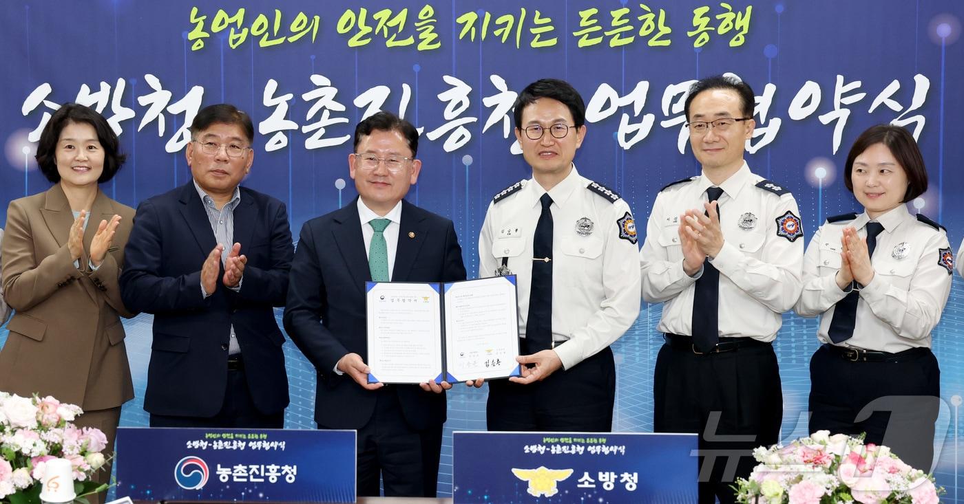 본문 이미지 - 김승룡 소방청장(오른쪽 세번째)과 이승돈 농진청장이 20일 세종시 소방청에서 농업기계 안전사고 예방·대비체계 구축을 위한 소방청·농촌진흥청 업무협약을 맺고 기념촬영을 하고 있다. 2026.4.20 ⓒ 뉴스1 김기남 기자