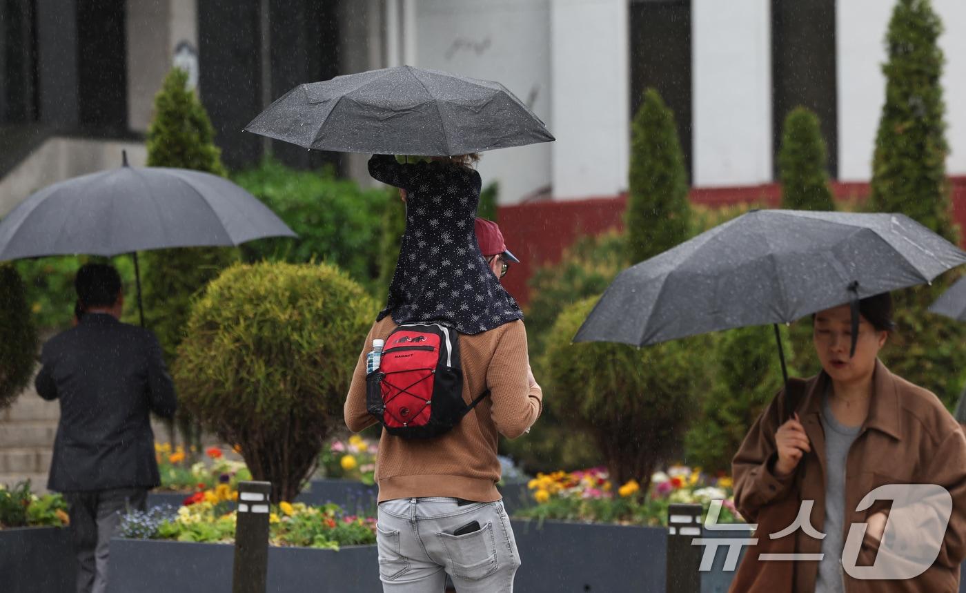 본문 이미지 - 20일 오후 서울 중구 시청역 인근에서 시민들이 우산을 쓰고 이동하고 있다. 2026.4.20 ⓒ 뉴스1 임지훈 인턴기자