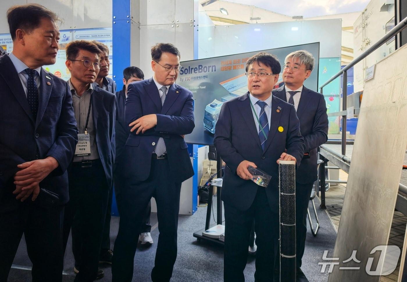 본문 이미지 - 20일 전남 여수 세계박람회장 일원에서 열린 제3차 유엔기후변화협약 기후주간과 기후에너지환경부 녹색대전환 국제주간에서 김성환 기후부 장관이 태양광 폐패널 처리기업 제품을 만지고 있다. ⓒ 뉴스1 황덕현 기자