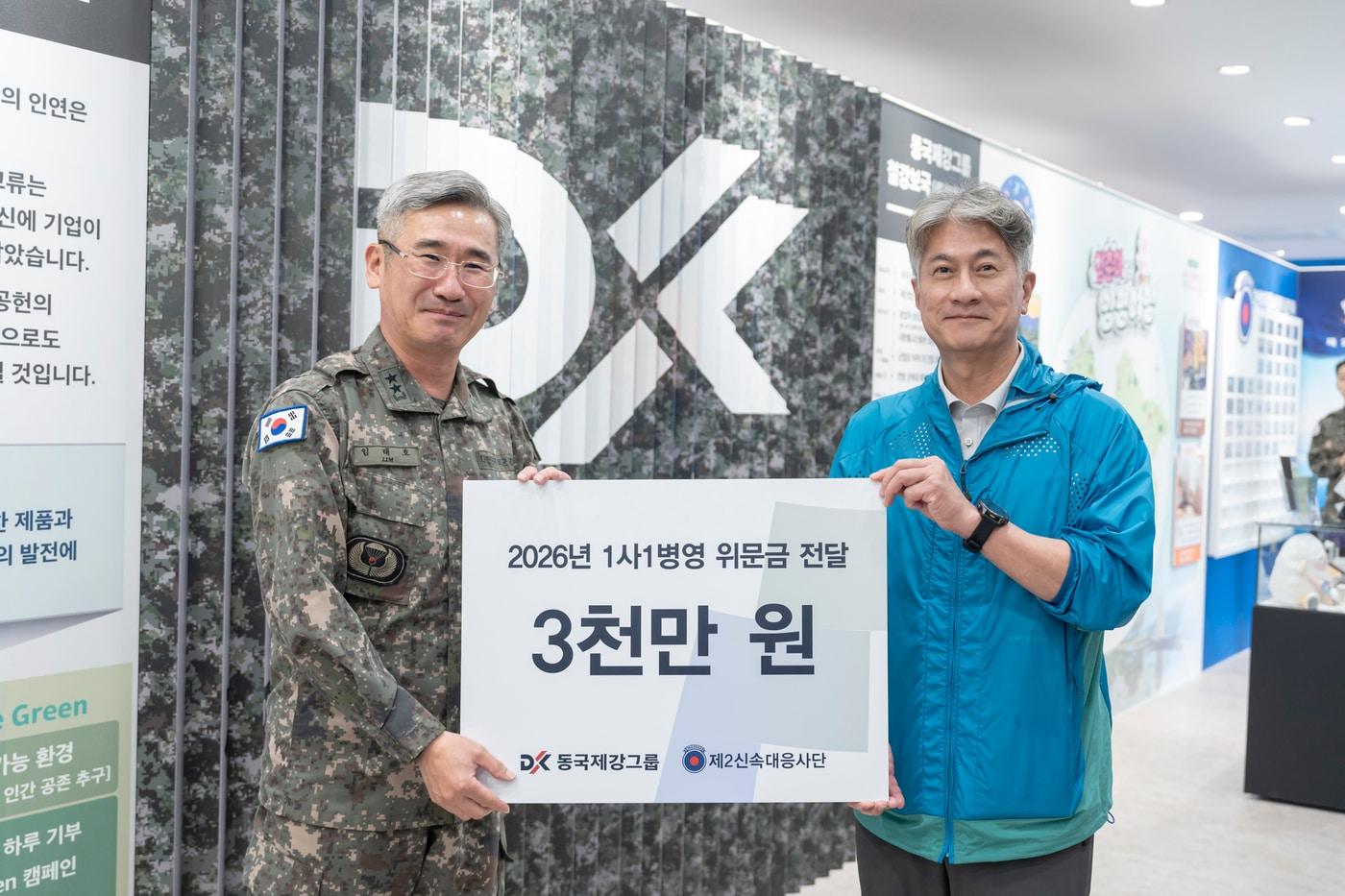 본문 이미지 - '동국제강그룹-제2신속대응사단 1사 1병영 행사 위문금 전달식'에서 장세욱 동국제강그룹 부회장(오른쪽)과 임태호 제2신속대응사단장(왼쪽)이 사단 역사관 내 '럭스틸 렌티큘러 월' 앞에서 기념사진을 촬영하고 있다. (동국홀딩스 제공)