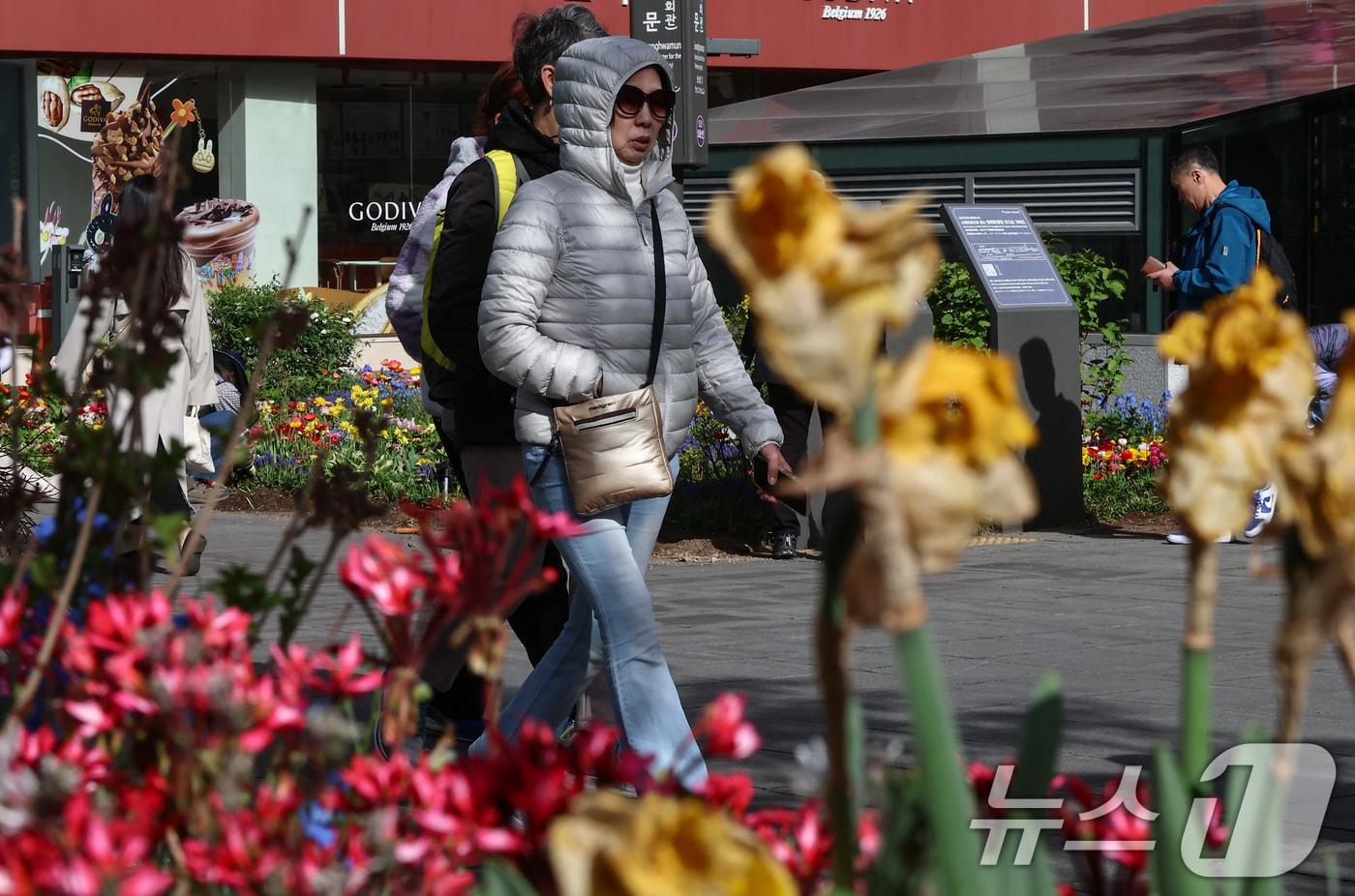 본문 이미지 - 쌀쌀한 날씨를 보인 21일 오전 서울 광화문네거리에서 두터운 옷을 입은 시민들이 길을 지나고 있다. 2026.4.21 ⓒ 뉴스1 김도우 기자