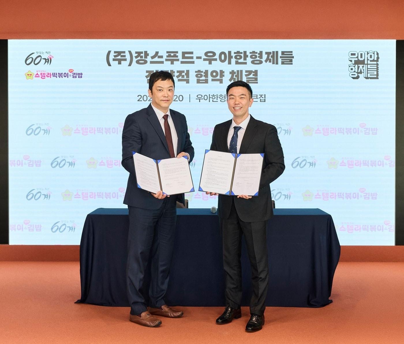 본문 이미지 - 배민 운영사 우아한형제들이 장스푸드와 배달 플랫폼 시너지 확대와 가맹점 매출 증대를 위한 업무 협약을 체결했다. 지난 20일 서울 송파구 우아한형제들 본사에서 김지훈 우아한형제들 사업부문장(오른쪽)과 장조웅 장스푸드 대표가 협약 체결 후 기념사진을 촬영하고 있다. (우아한형제들 제공)